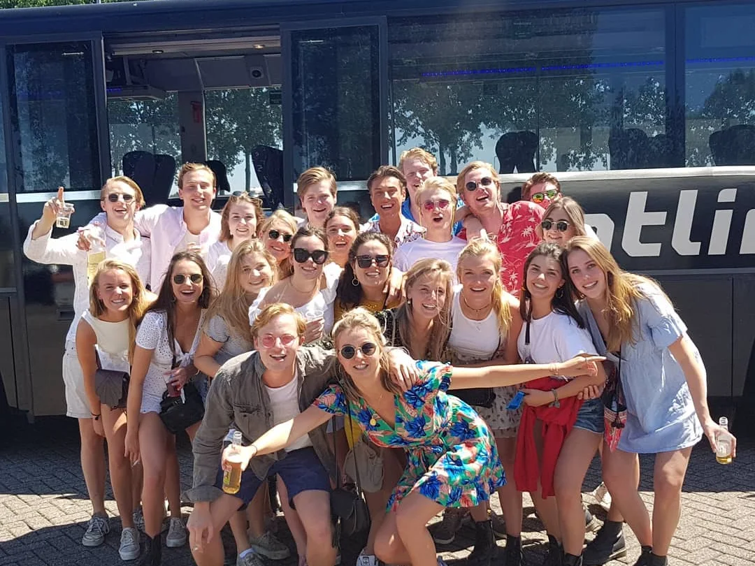 Feestelijke groep bij de partybus